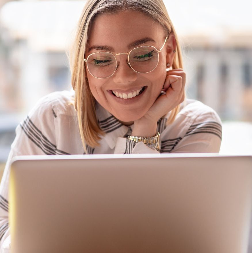 woman wearing blue light glasses to protect against under eye wrinkles