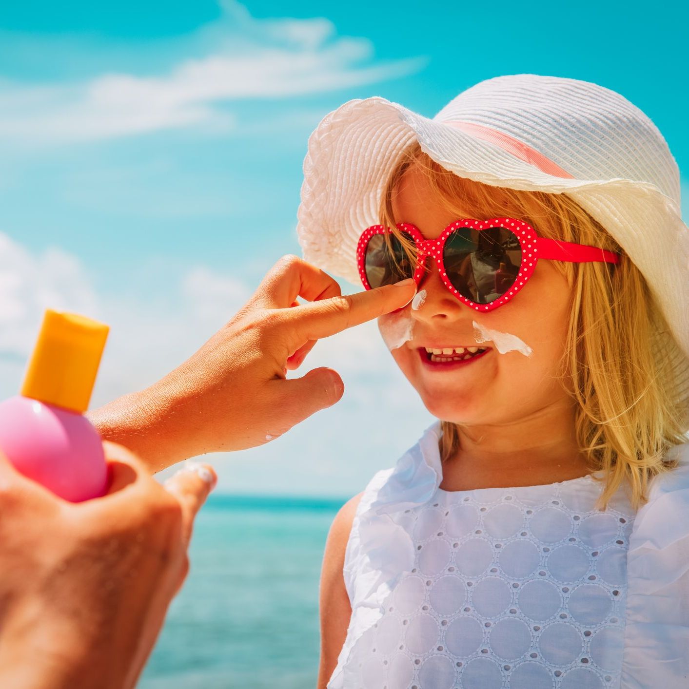 child wearing uv protection with sunglasses, hat and sunscreen child wearing uv protection with sunglasses, hat and sunscreen